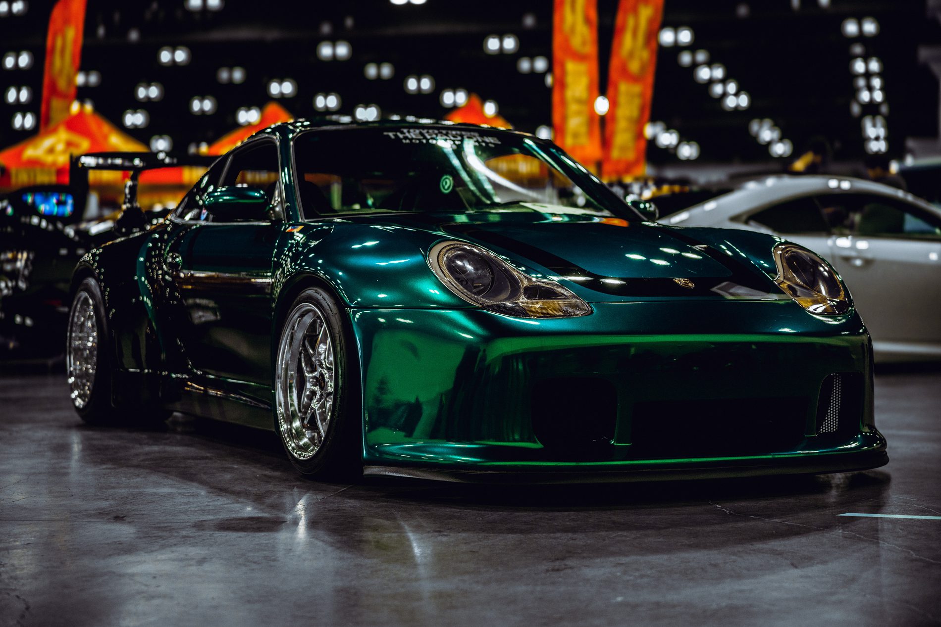 Widebody Porsche 911 lit against night bokeh
