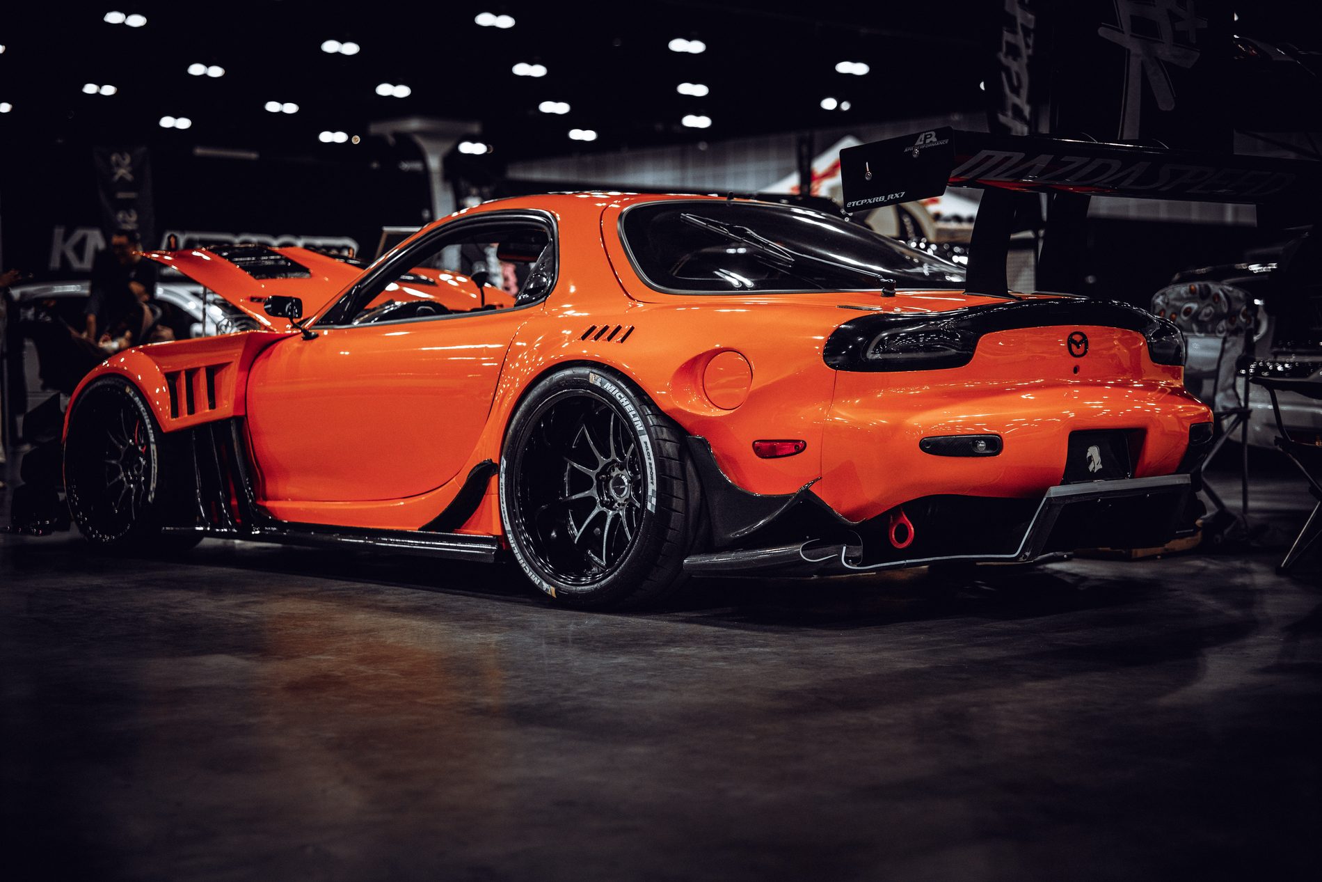 Orange widebody Mazda RX-7 on the show floor